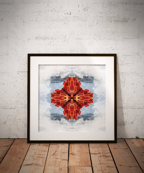 Framed abstract art print with a red geometric design on a white wall.