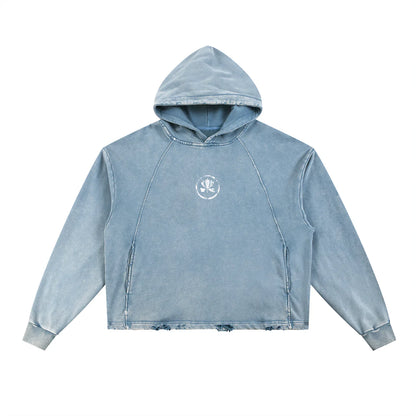 Washed blue distressed hoodie with small white crest logo on chest, streetwear style